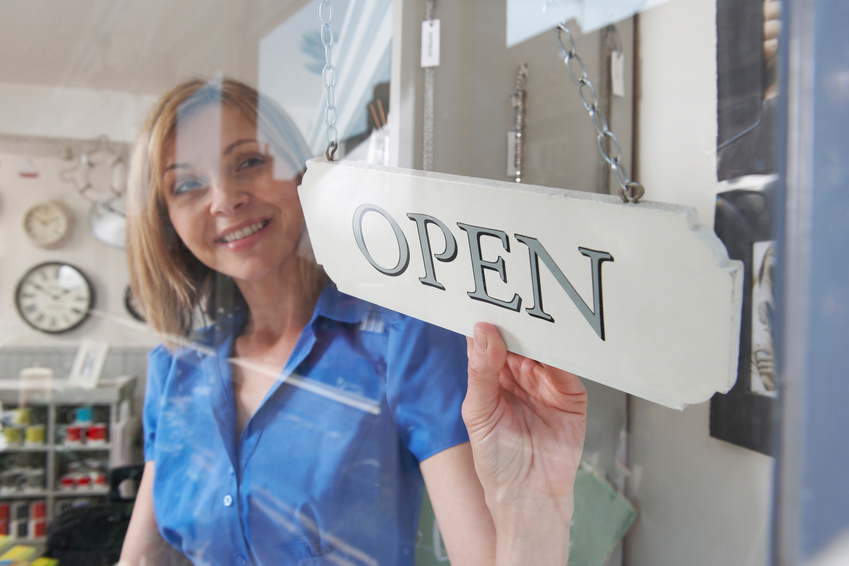 Verk&auml;uferin mit Schild "Open"