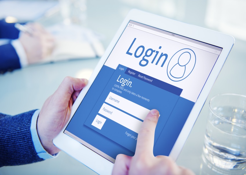 Ein Finger tippt auf einem Tablet Login-Daten ein