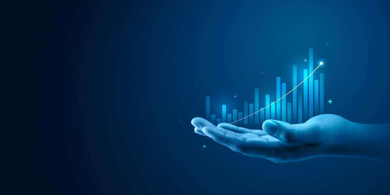 Eine Hand hält eine digitale Konjunkturkurve