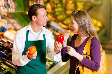 Frau im Supermarkt und Verk&auml;ufer