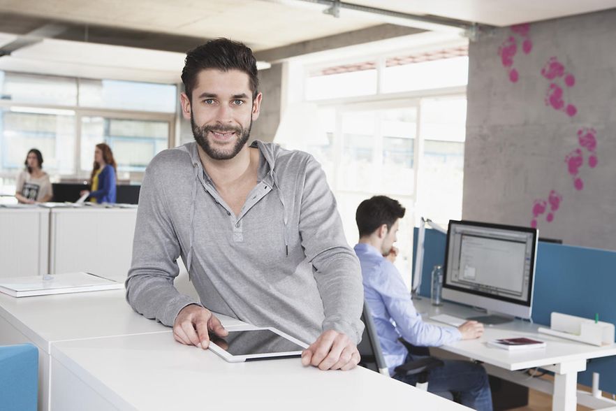 Mann am Schreibtisch mit Tablet-PC