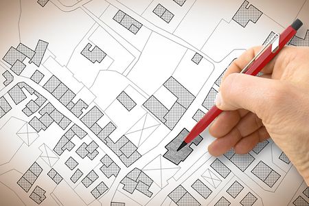 Hand drawing an imaginary cadastral map of territory with buildings and roads