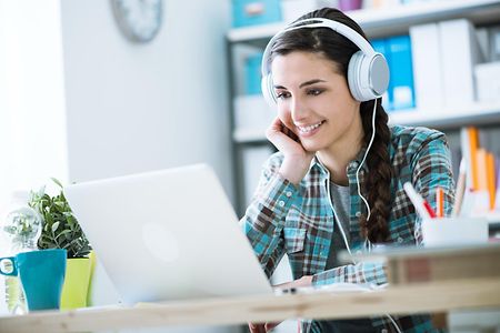 Girl with headphones using a laptop