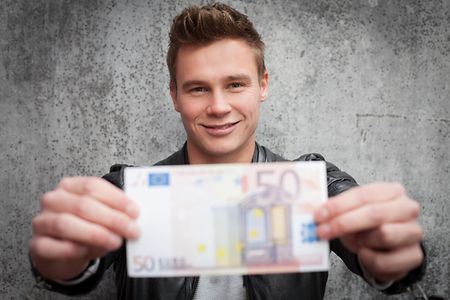 Attractive young guy holding fifty euro note