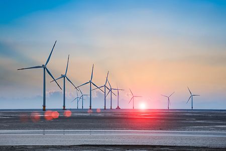 wind turbine farm with rays of light at sunset