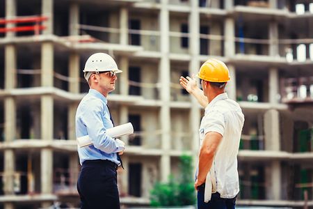 Architect and builder discussing at construction site