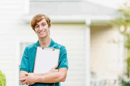 Smiling man with clipboard doing door to door canvassing