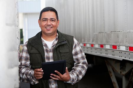 Hispanic truck driver with digital tablet