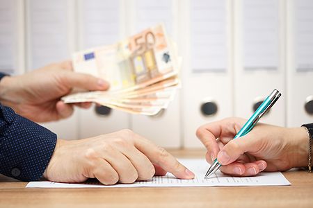 Vertrag wird unterschrieben und Geld &uuml;berreicht