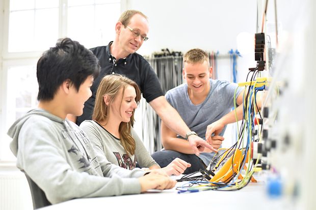 Lehrer zeigt Sch&uuml;lern einen technischen Baukasten