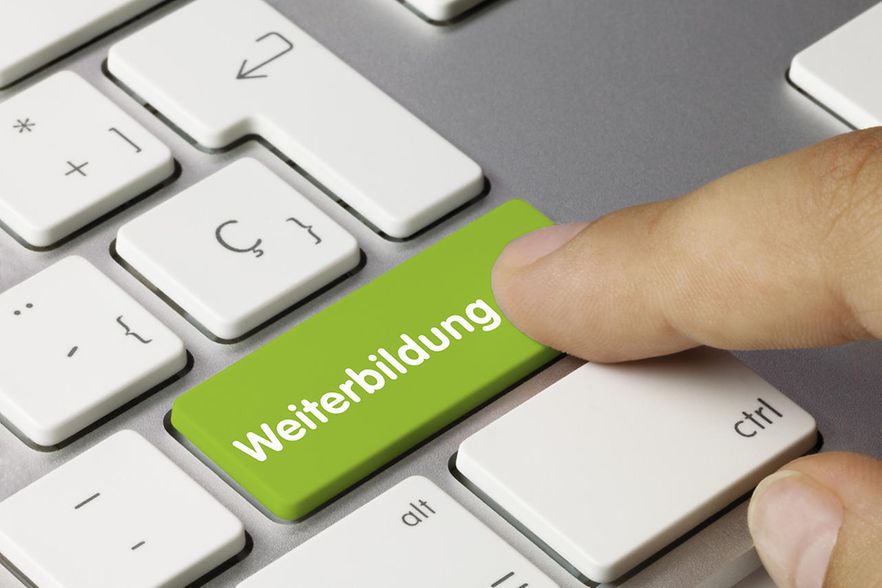 Finger zeigt auf Computertastatur mit Aufschrift Weiterbildung