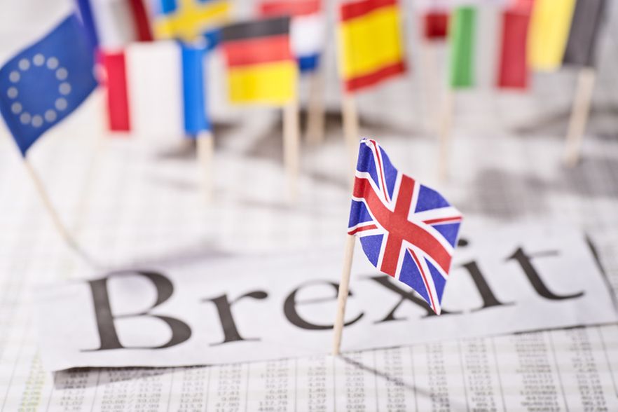 Der Schriftzug Brexit liegt auf einer Zeitung. Darin stecken unterschiedliche Flaggen europ&auml;ischer L&auml;nder.