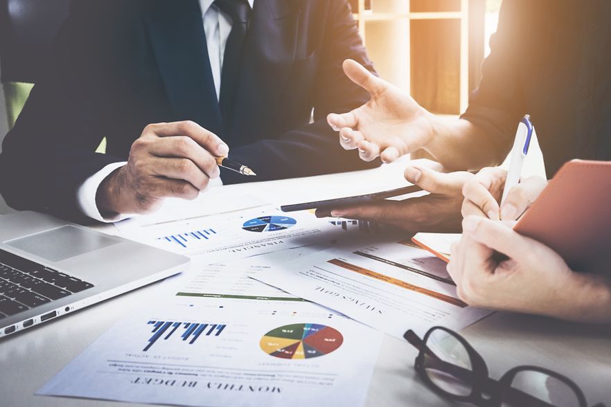 Gestikulierende Personen an einem Tisch mit Statistiken