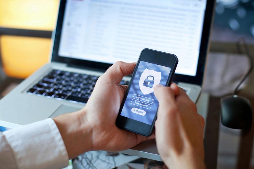 Auf einem Handy werden die Login-Daten eingegeben