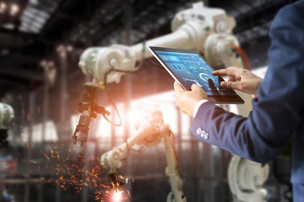 Ein ingenieur hält ein Tablet in der Hand. Das Bild steht für künstliche Intelligenz in der Industrie