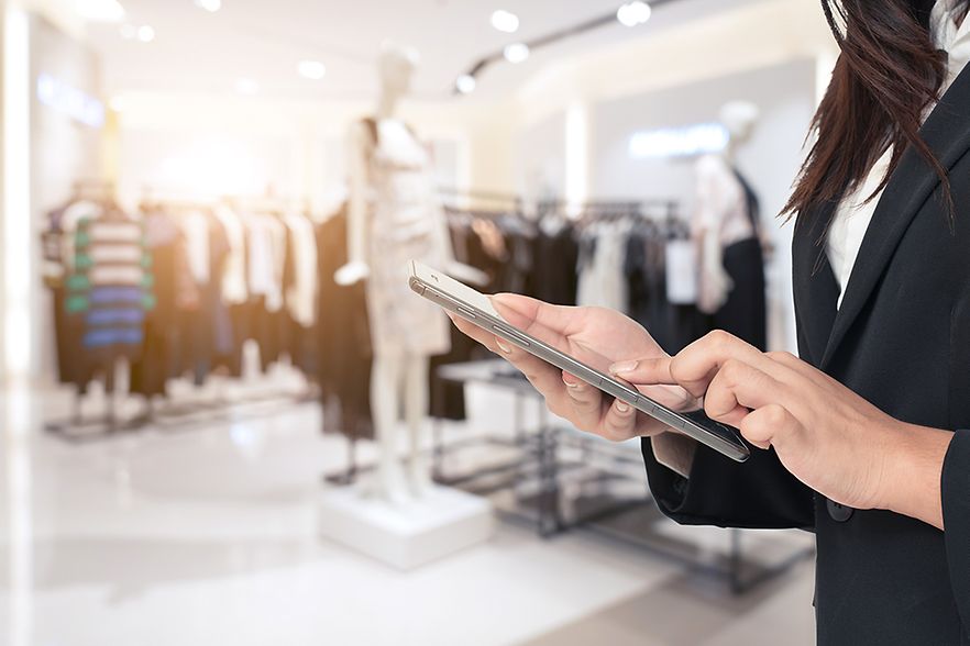 Verk&auml;uferin in Boutique mit Tablet in der Hand