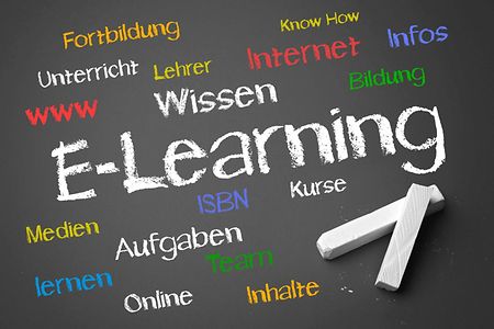 Tafel mit Kreide und dem Schriftzug "E-Learning" und Unterbegriffe dazu.