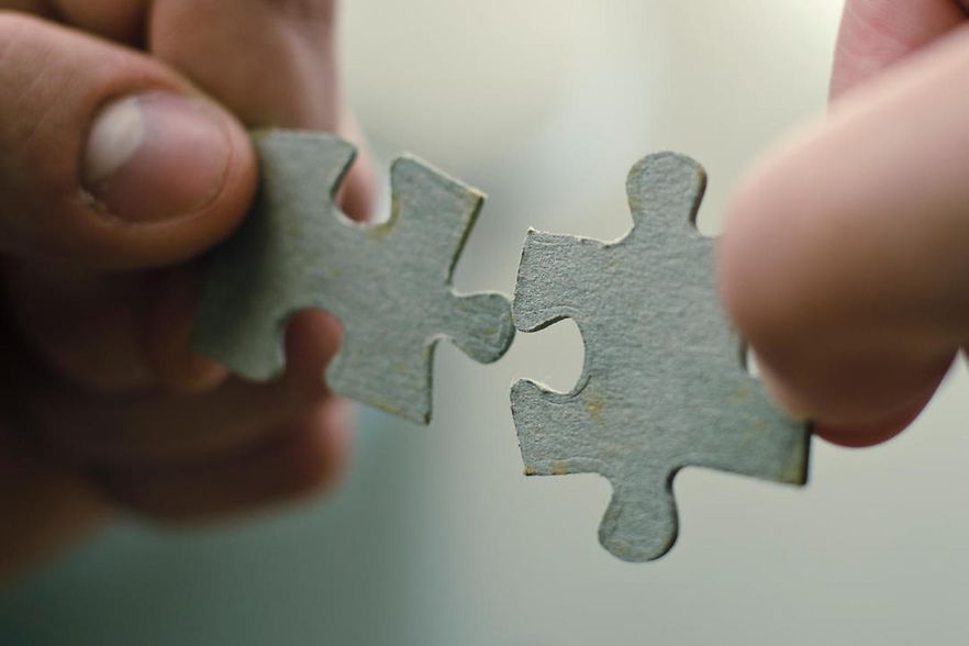 Zwei Puzzleteile werden zusammengef&uuml;gt