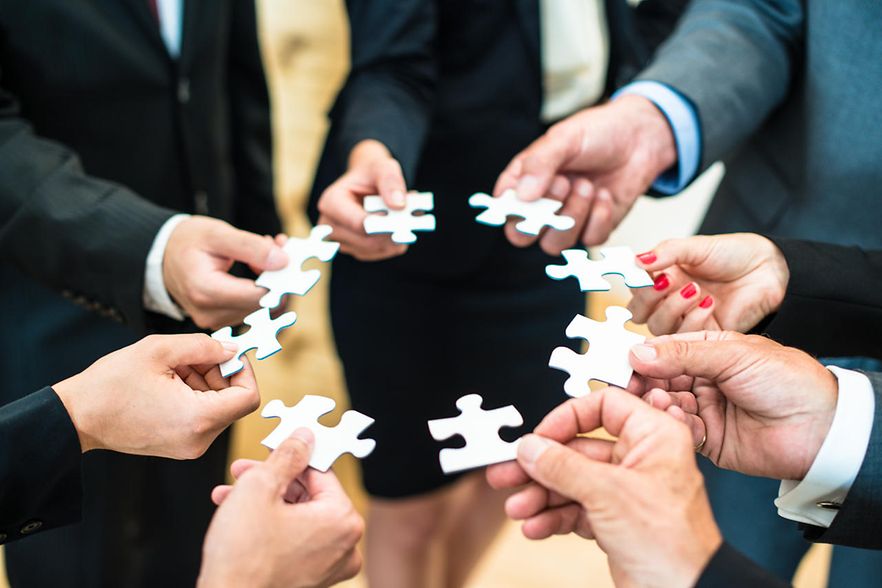 H&auml;nde halten Puzzleteile zusammen