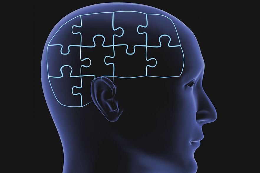 Blauer Kopf mit Puzzleteilen als Gehirn