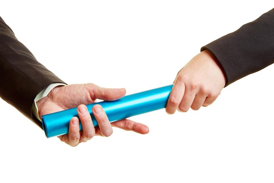 Hand &uuml;bergibt blauen Staffelstab an andere Hand