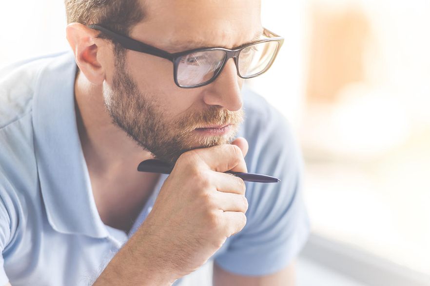 Mann mit Brille, nachdenklich aufgest&uuml;tzt