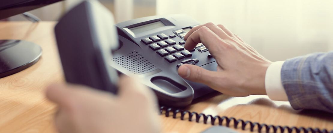 Ein Gesch&auml;ftsmann w&auml;hlt eine Telefonnummer