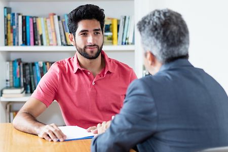 junger Migrant im Beratungsgespr&auml;ch