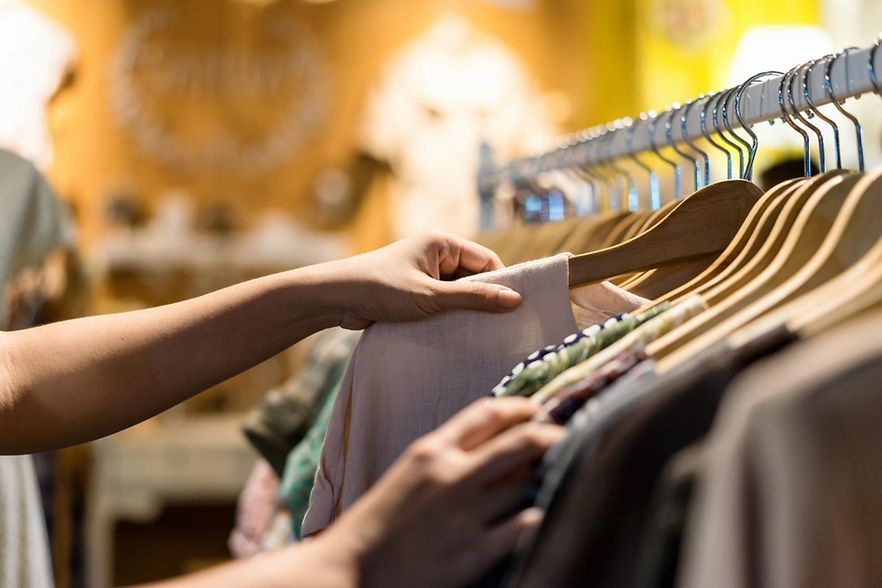 Kleiderstange mit Hand, welche ein Kleidunsst&uuml;ck ausw&auml;hlt