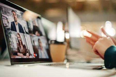 Videomeeting - Laptop mit gestikulierenden H&auml;nden vor dem Bildschirm