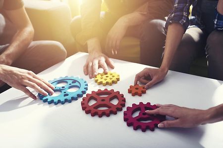 Verschiedene Zahnr&auml;de greifen ineinander, liegend auf einem Tisch