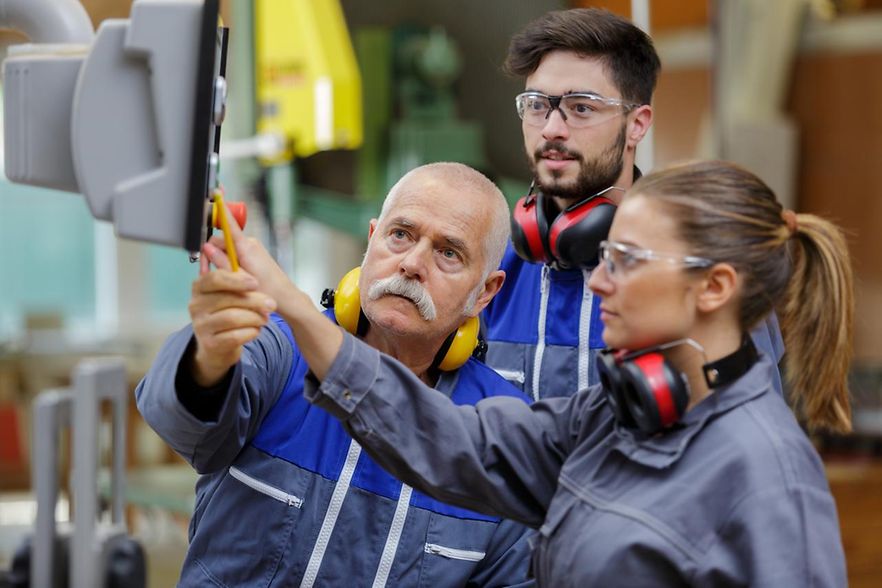 2 M&auml;nnder, 1 Frau beim Arbeiten mit Geh&ouml;rschutz