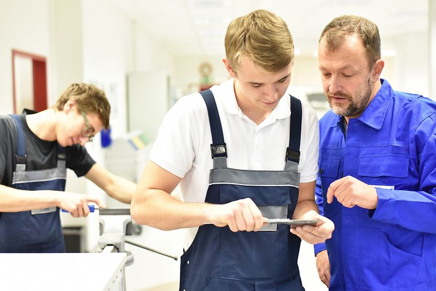 Ausbilder erkl&auml;rt Lehrling etwas
