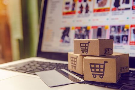 Pakete mit Aufdruck Einkaufswagen auf Laptop
