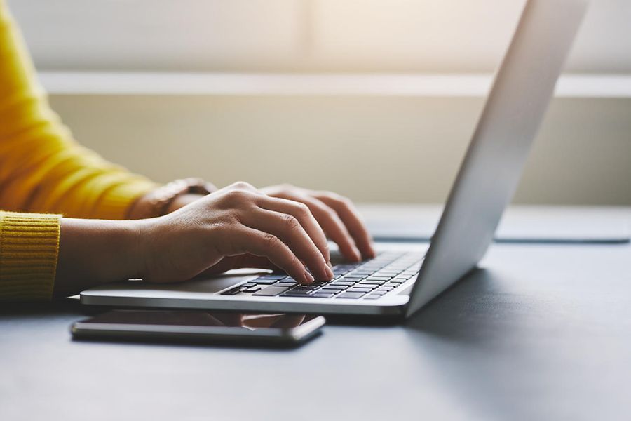Eine Frau schreibt etwas auf einen Laptop
