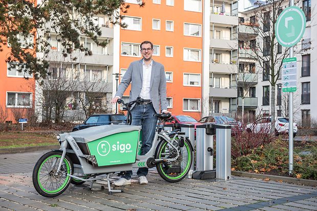 Tobias Lochen mit E-Cargo-Bike vor Wohngeb&auml;uden