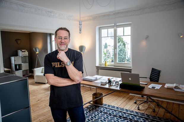J&uuml;rgen Ludwig stehend vor dem Schreibtisch in seinem Arbeitszimmer
