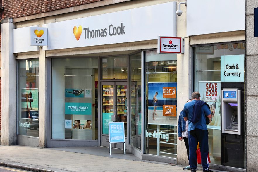 Leute stehen vor Thomas Cook Reiseb&uuml;ro. 