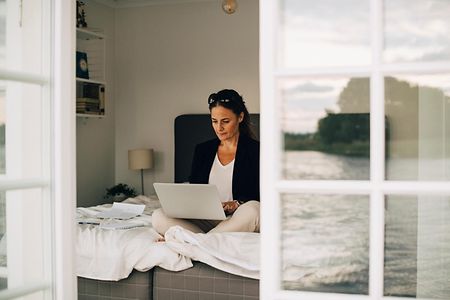 Frau mit Laptop im Ferienhaus