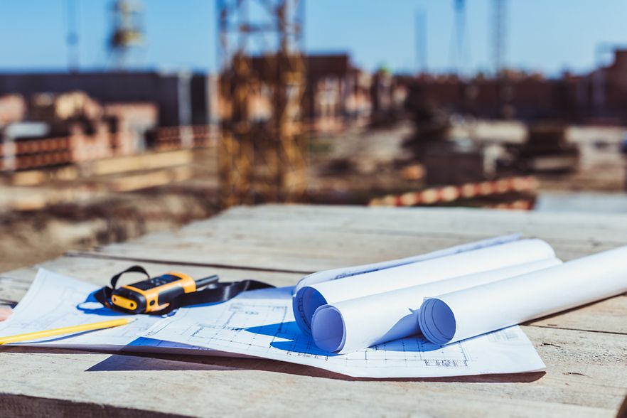 Baupl&auml;ne und Walkie-Talkie auf einem Tisch einer Baustelle. 
