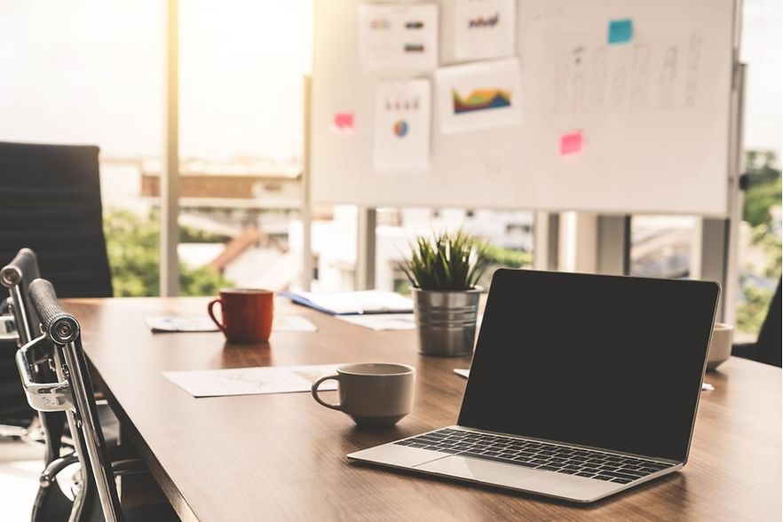 Businessraum mit Laptop und Tassen auf dem Tisch