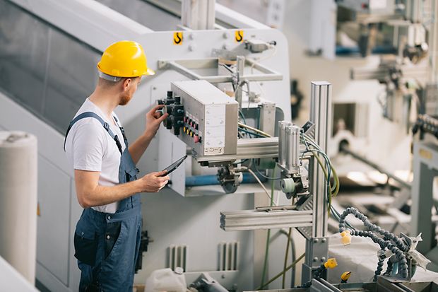 Fabrikarbeiter an Maschine