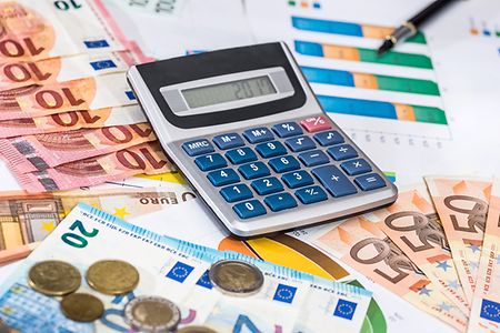 Taschenrechner liegt auf Euroscheinen