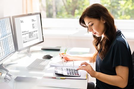 junge Frau macht am Computer die Buchhaltung