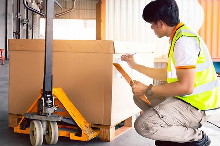 Worker is inspecting large shipment box for load to transport
