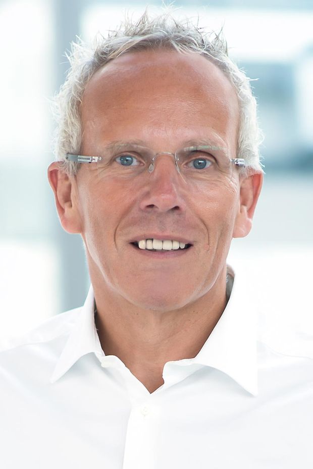 Ein Mann in einem weißen Hemd und mit Brille im Porträt. 