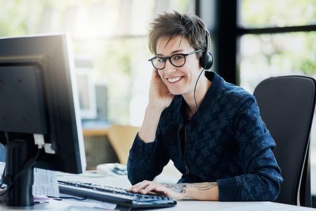Frau mit Headset am PC