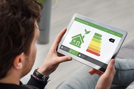 Mann h&auml;lt Tablett in Hand, wo ihm gezeigt wird, wie er Energie sparen kann