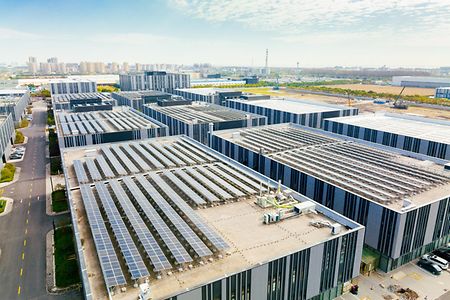Aerial view of solar panels on factory roof. Blue shiny solar photo voltaic panels system product.
