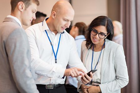 Ein Paar mit Smartphone auf einer Business-Konferenz